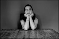 a black and white photo of a woman sitting at a table