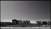 a black and white photo of buildings on the beach